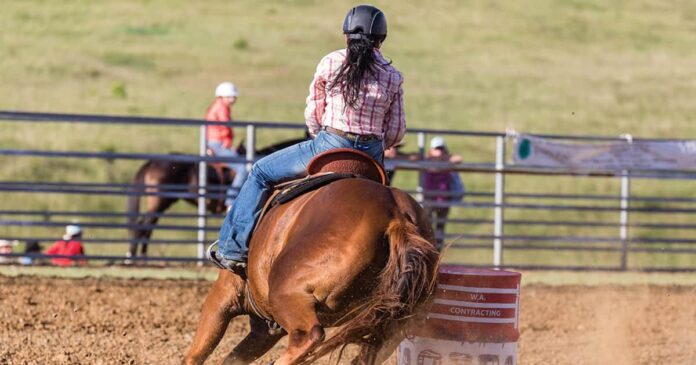helmet barrel Barrel racer wearing a helmet and riding her horse around barrel. Recognising concussion.